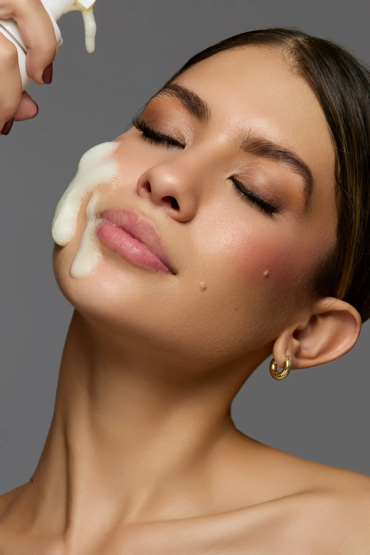 Modelo con espuma GLOW sobre la mejilla