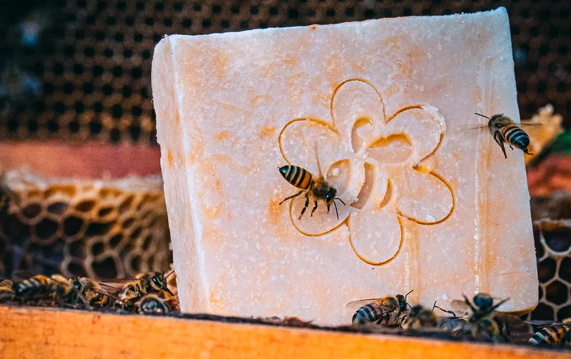 Jabón artesanal de miel con abejas reales sobre la colmena